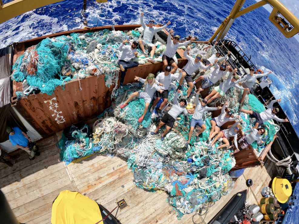 A marine debris removal team with a large haul of recovered fishing nets and other waste
